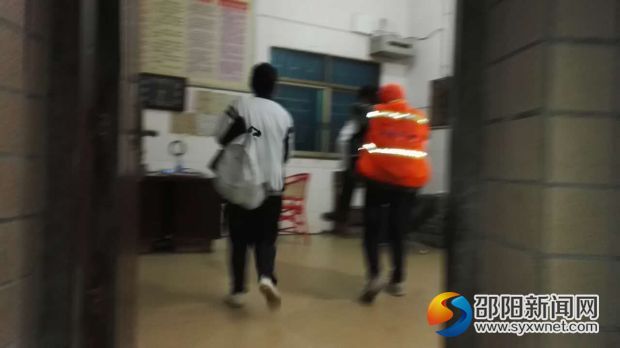 两位爱心新邵一中学生背着环卫工走进校传达室