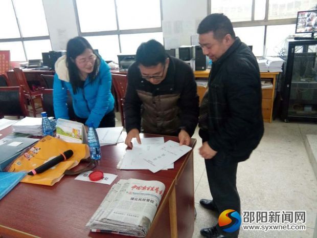 关峡乡政府工作人员在关峡学校查看校车安全工作相关资料