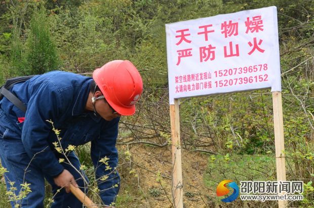国网邵阳供电公司员工在电力设施保护区设立防山火警示牌