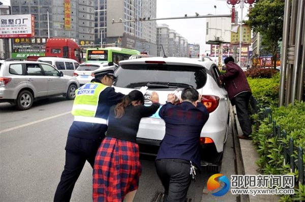 图为交警帮半路熄火的车主推车排障碍