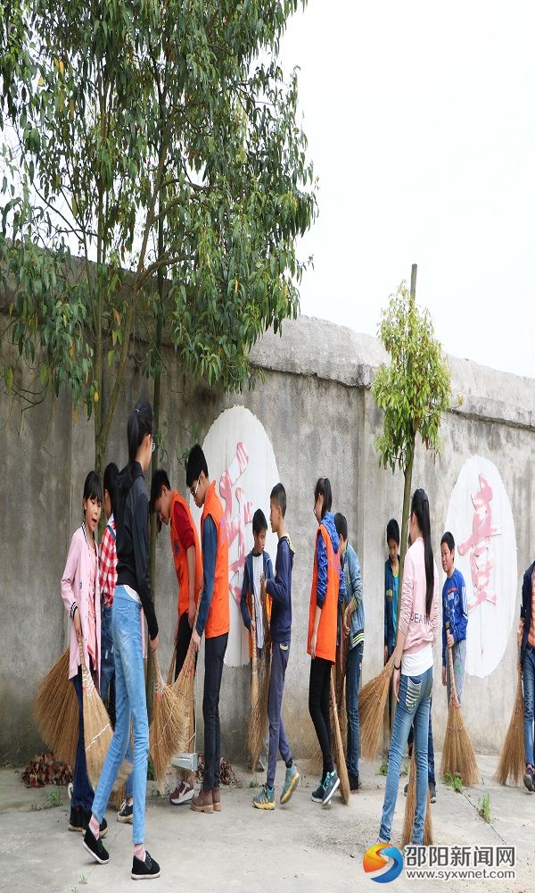 志愿者与小朋友一起打扫校园