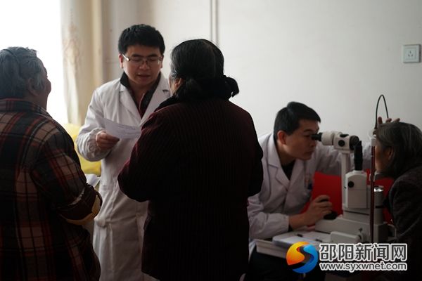 图为医务人员在乡下为老人进行眼科检查