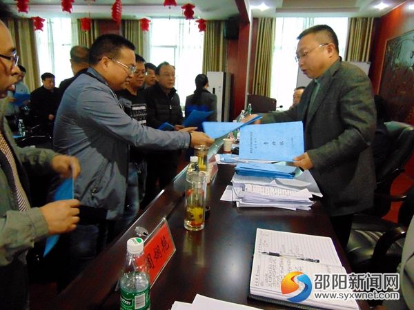 图为医疗单位负责人向上级单位领导递交安全生产责任状