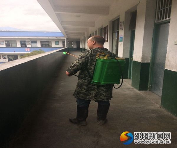 新宁县黄金中心小学工作人员对校园进行全面消毒