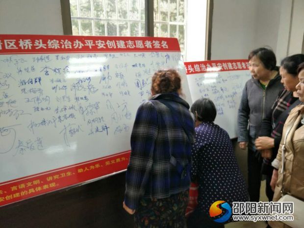 居民群众在平安创建志愿者签名墙上签名