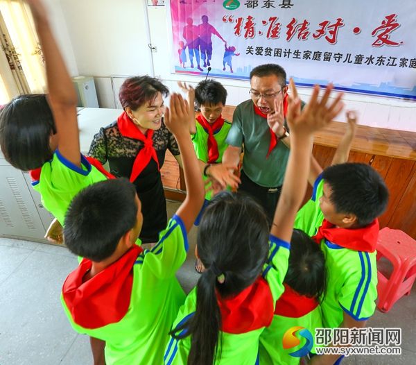 图为计生协干部与贫困计生家庭留守儿童互动