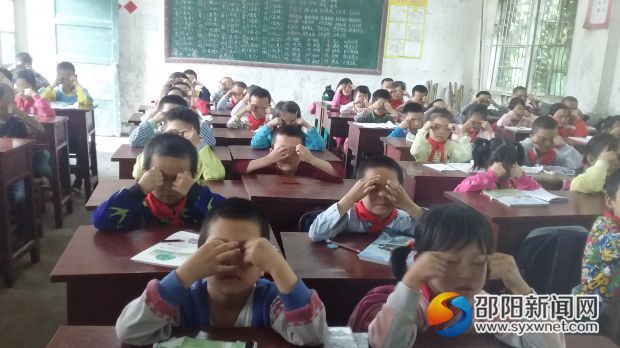 一年级二班的学生们正在做眼保健操操