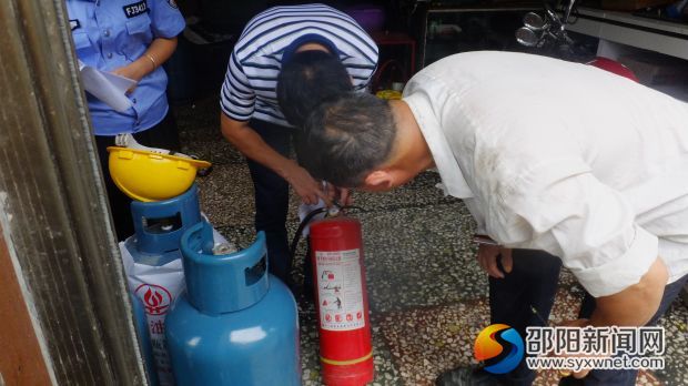 检查人员在检查液化气经营店消防器材