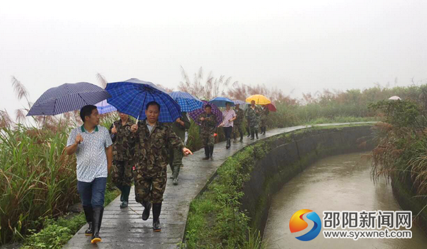 图为该站共产党在雨中巡查渠道运行情况