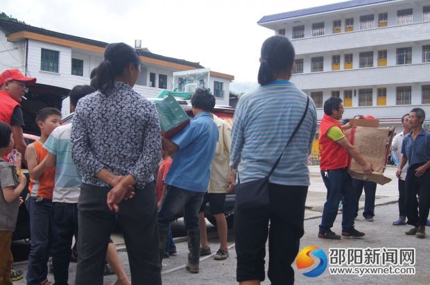 图为大邵公益志愿者将物资送到灾民手中