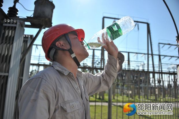 高温下，电力员工抢修完成后，一口气喝掉一瓶水
