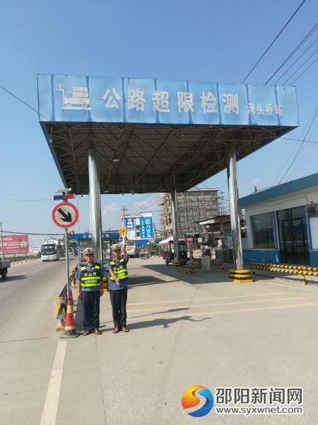 武冈市湾头桥公路超限检测站站内执法人员引导车辆入站检测