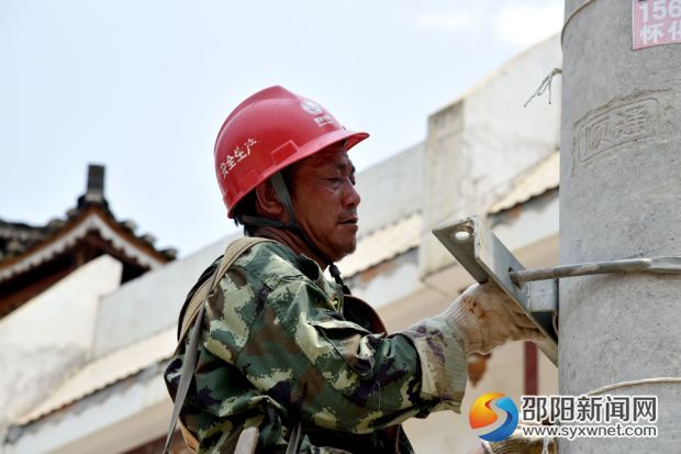在绥宁县金屋塘镇，检修人员脸庞已被晒得黑里透红的电力施工人员，在烈日下对金屋镇10千伏金张线红万支线杆上的导线与瓷瓶进行更换。 (7)