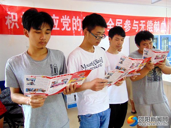 应征入伍青年在阅读无偿献血宣传资料