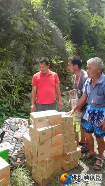 左一为张建为灾民发放救灾物资