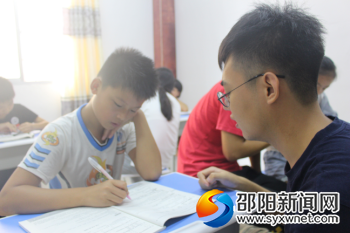 团队成员在为爱心书屋的孩子们辅导功课