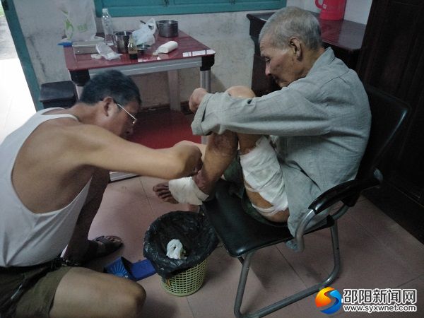 民政局工作人员正在为刘有志老人包扎创口