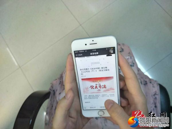 群众认真阅读“新邵检察”微信公众号。