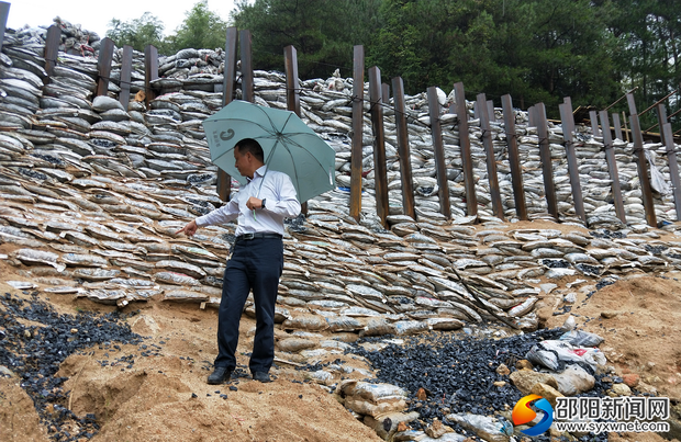 检查组人员在仔细检查山体渗水情况