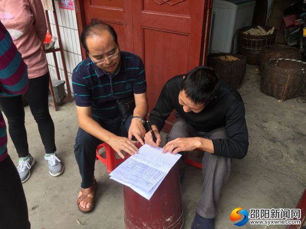 图为肖明菊和贫困户探讨制订脱贫方案