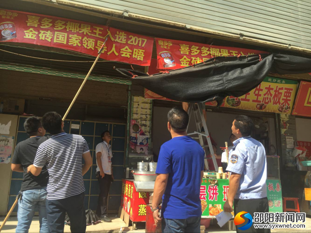 图为该镇镇长邓亦锋指挥拆横幅