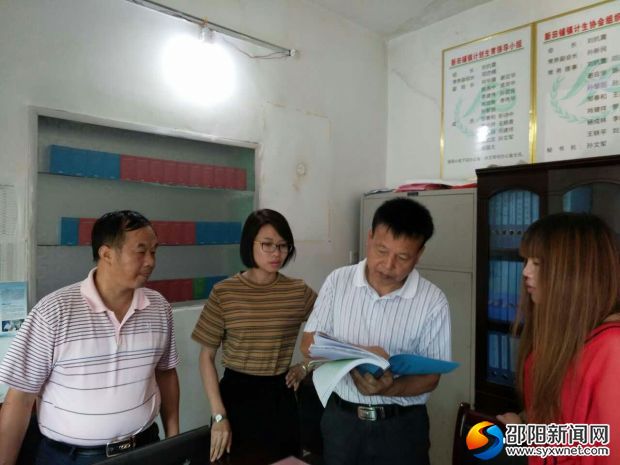 图为杨建新在审核计生协会资料