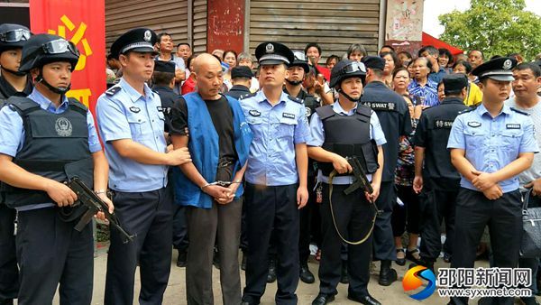 图为被押解的故意杀人嫌疑犯