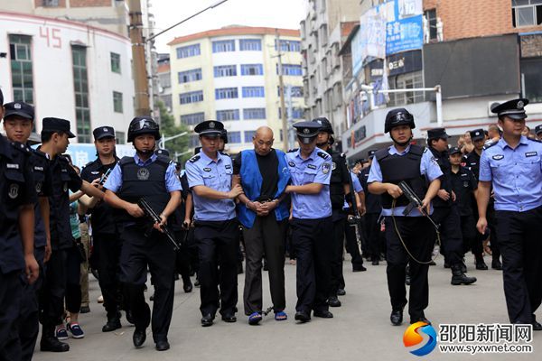 图为故意杀人嫌疑犯被押往案发地指认现场