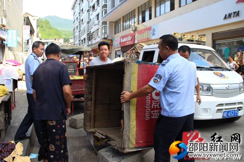 工作人员帮助门店店主清理摆出店外的摊位