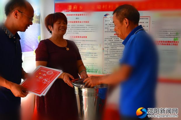 图为周家村党支部书记周党云给受奖者颁奖
