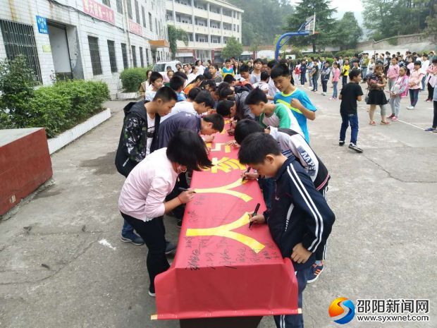 全体学生在横幅上郑重地签上自己的名字