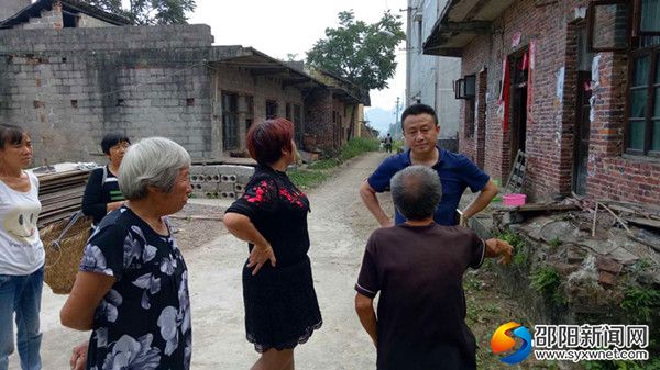 潭府乡党委书记刘文杰与周家村贫困户交流