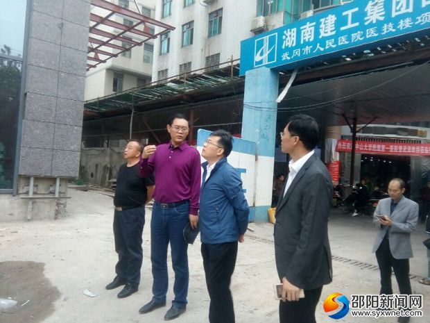 督查组在武冈市人民医院门诊医技住院综合楼前查看项目进度