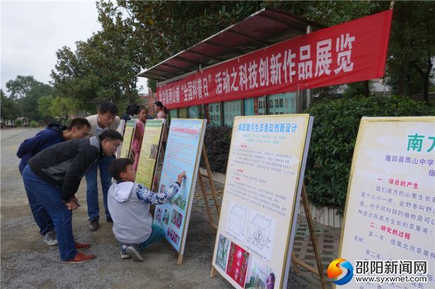 二、隆回县科协主席范吉权（前排左一），与雨山铺领导一道，在欣赏雨山中学科技组学生讲解项目创新点。DSC05211