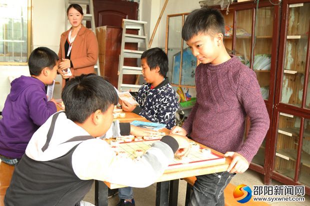 新邵县小塘镇言栗完小少年宫的棋牌室内,孩子们正在进行对弈