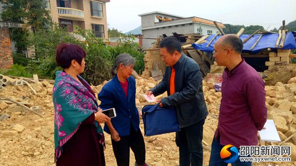 新邵一中党总支书记屈宋来给贫困户李任美送慰问金