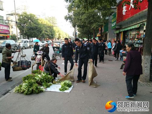 执法人员正在劝诫占道摆摊者