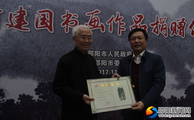 禹新荣（右）向何建国颁授收藏证书。