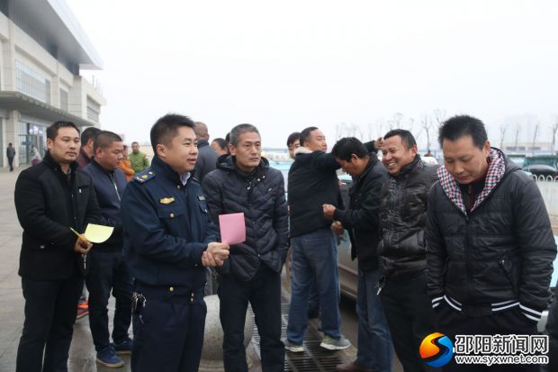 执法人员向出租车驾驶员宣传专项整治行动的精神
