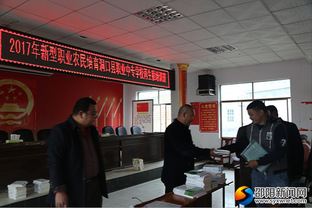 洞口职中教师为学员发放教材及教案