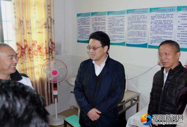 梁文明(中)在湾头桥镇泻油村卫生室与村医交谈