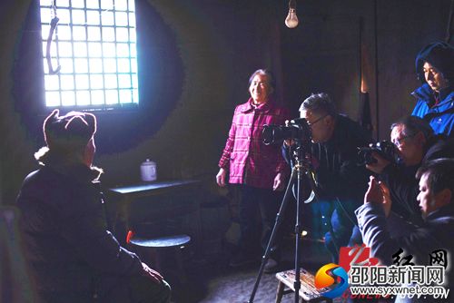 摄影家在村里为老人家拍摄照片一幕