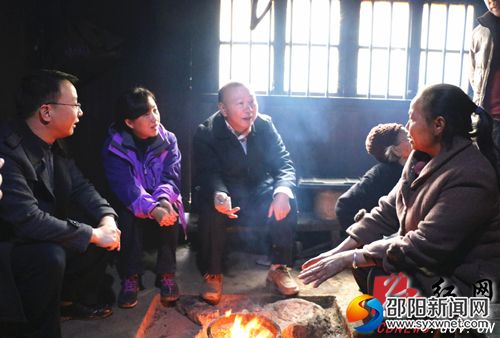罗建南在古田村贫困户罗进绿家与其家人促膝谈心