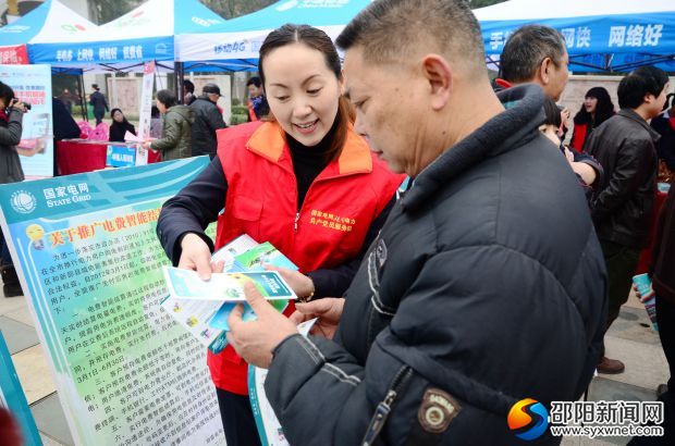国网邵阳供电公司员工向客户介绍手机缴费服务功能