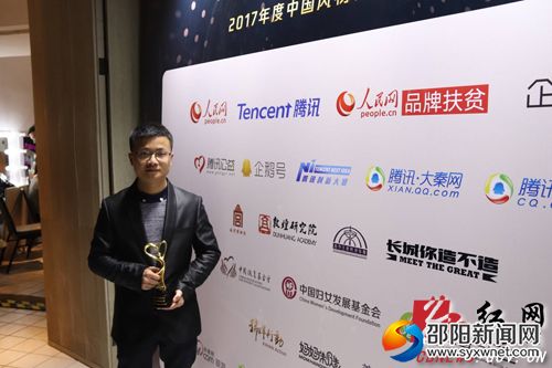天元农业开发有限公司总经理肖布闻手持&ldquo;扶贫创新企业&rdquo;奖杯