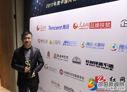 天元农业开发有限公司总经理肖布闻手持“中国扶贫创新企业”奖杯