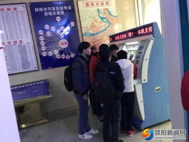 市民们在自助购票机前买车票。