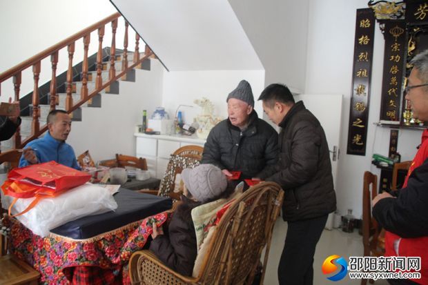 图为城步民政局领导送上慰问金