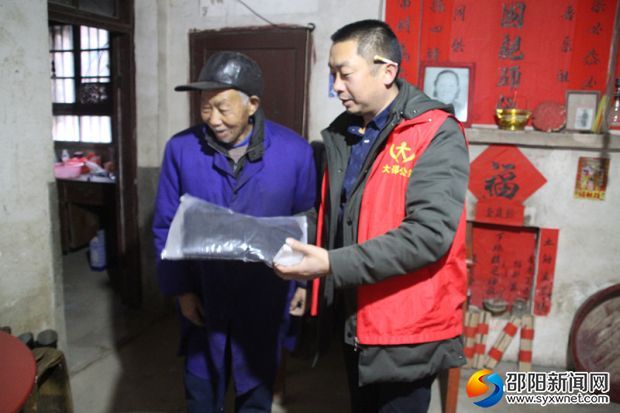 图为志愿教老人使用电热衣服