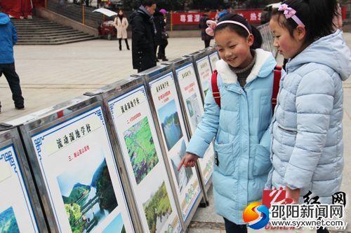 　　小学生在观看宣传展板